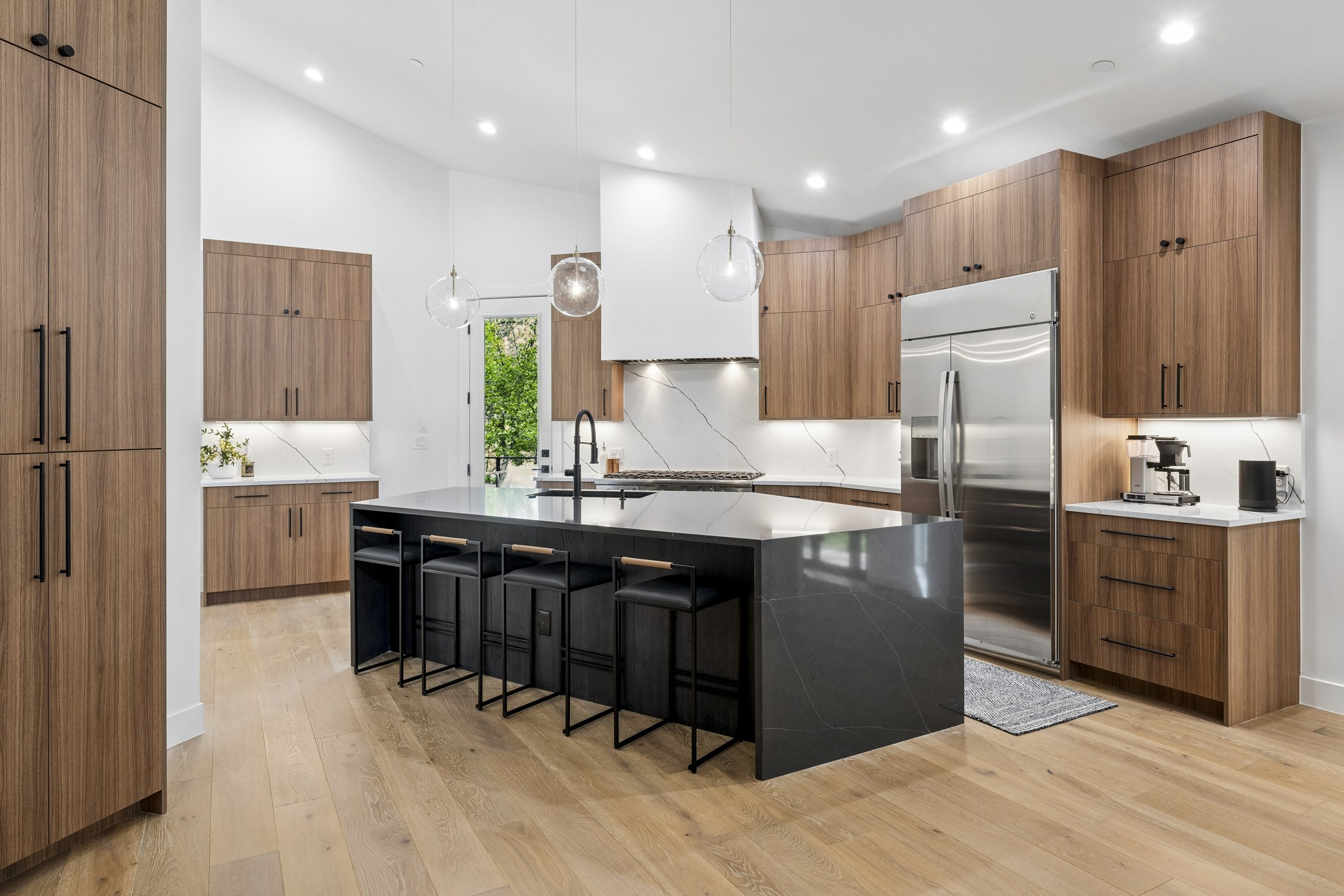 Relocated kitchen with wood cabinetry and a dark island